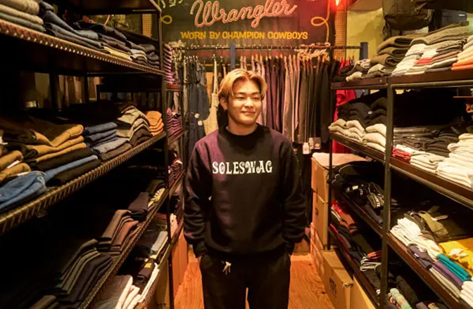 金髪に黒に白文字の「SOLESWAG」のロゴが入ったスウェットを着た男性スタッフの一枚