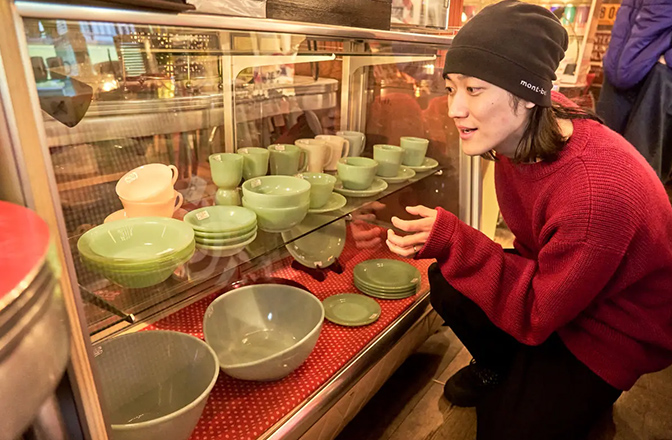 グリーン系の色合いが美しい食器が並ぶ棚に夢中のハルキさん