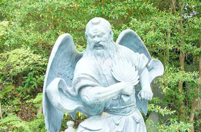 高い鼻、団扇を持ったお姿の大天狗の銅像
