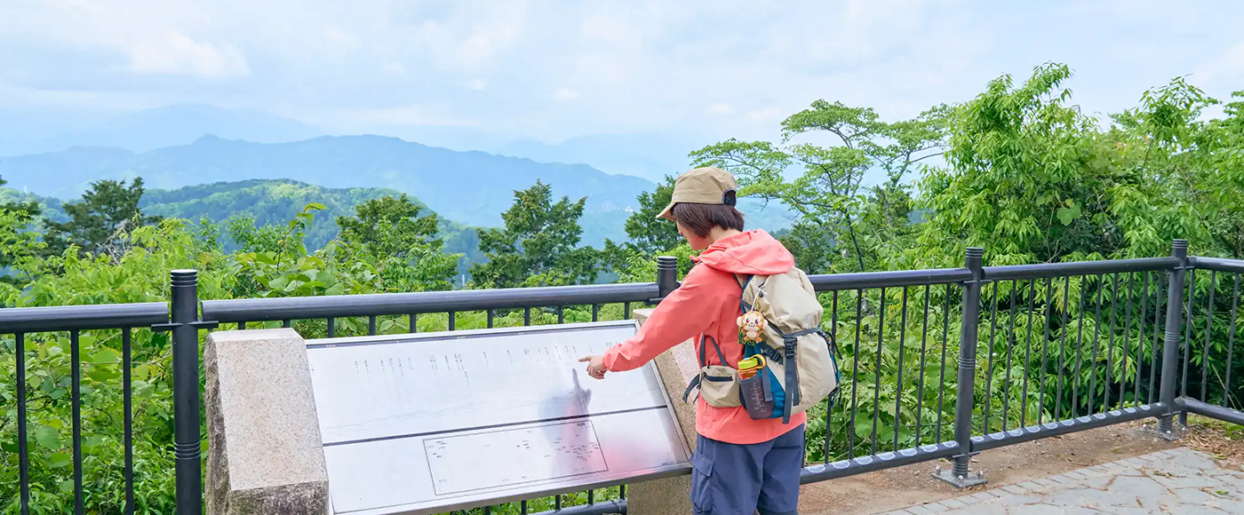 掲示板を見ながら、そこから見える山の位置と名称を照らし合わせるかほさん